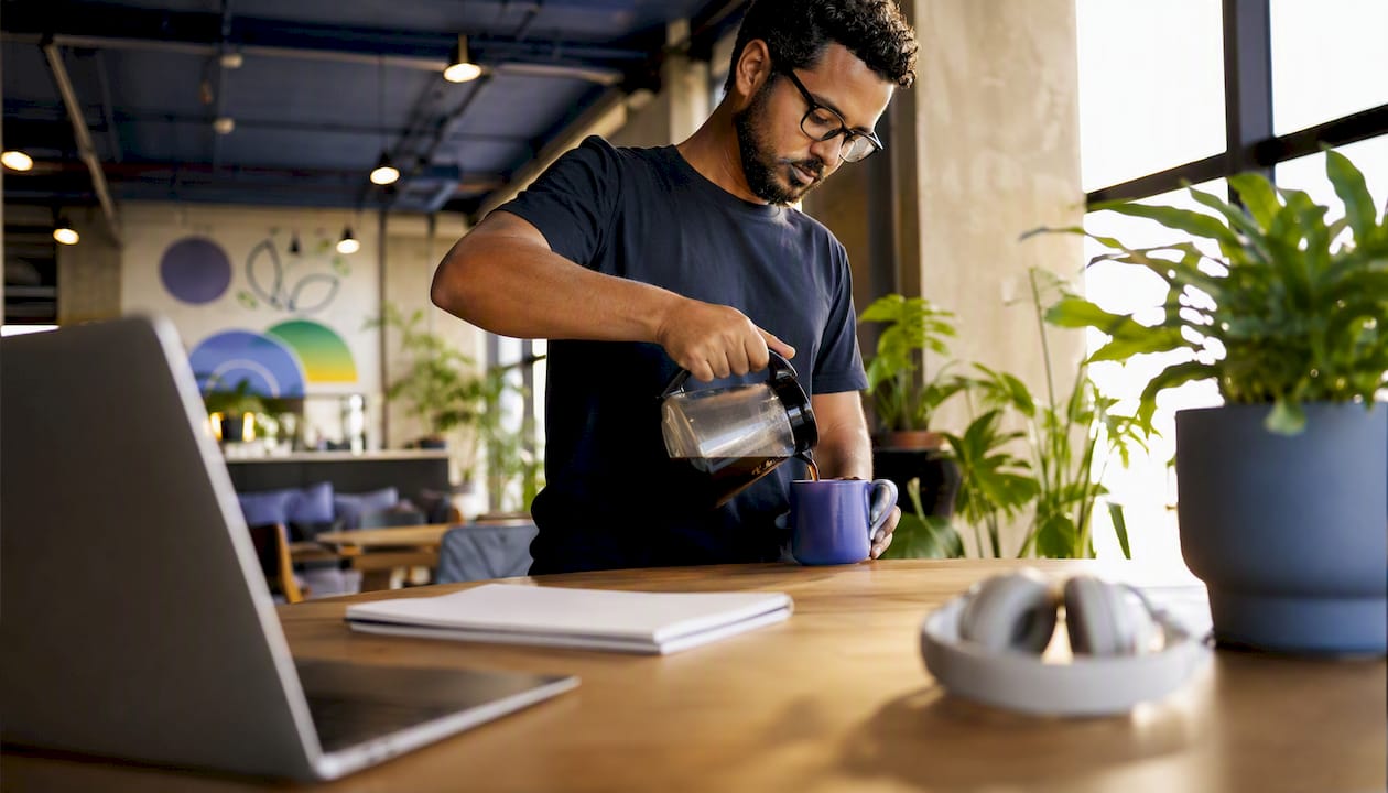 Developer pouring coffee during remote sprint work