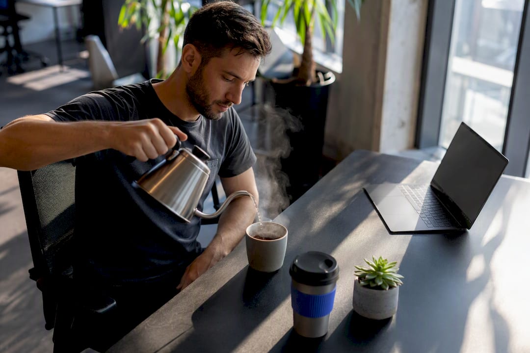 Developer pouring coffee in office kitchen corner